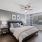 Furnished Bedroom With Ceiling Fan And Large Window At The Victor Verdae Apartments